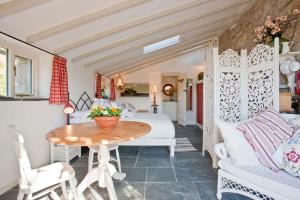 a bedroom with a bed and a table and chairs at The Studio Cottage, with, Sea views, Garden, Amazing Location by beach in Sennen