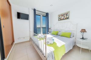 a white bedroom with a bed and a window at Apartamento Bellavista Puerto 2A in Cala Ratjada
