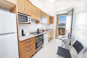 a small kitchen with a table and a refrigerator at Apartamento Bellavista Puerto 2A in Cala Ratjada +23 photos