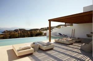 a patio with couches and a swimming pool at PAROCKS Luxury Hotel & Spa in Ambelas