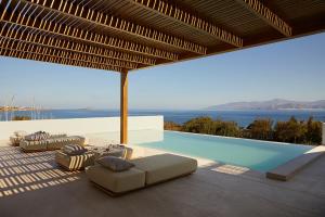 a pool with lounge chairs and a view of the ocean at PAROCKS Luxury Hotel & Spa in Ambelas