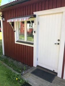 un garaje con una puerta blanca y una ventana en Gävle Järvsta nära Furuvik och centrala Gävle en Gävle