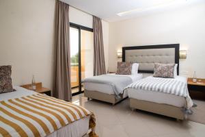 um quarto de hotel com duas camas e uma janela em HOTEL DES THERMES em Tarmilet