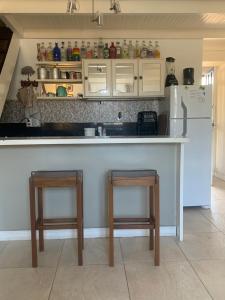 a kitchen with a counter with two chairs and a refrigerator at Boutique-Apartamento Vidabuena Buzios - MYNAPARTAMENTOS in Búzios +19 photos