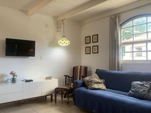 a living room with a blue couch and a tv at Boutique-Apartamento Vidabuena Buzios - MYNAPARTAMENTOS in Búzios