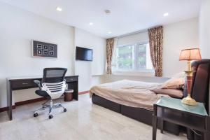 1 dormitorio con cama, escritorio y silla en The Center of Singapore; China Town en Singapur