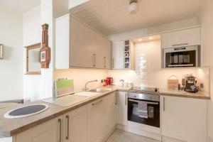 a kitchen with white cabinets and a sink at Stunning Panoramic Views: Heart of the Royal Mile in Edinburgh