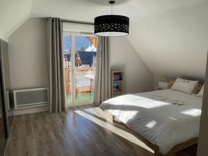 une chambre avec un lit et une grande fenêtre dans l'établissement Appartement duplex de standing au cœur des Pyrénées, à Luchon