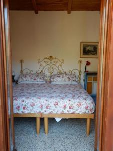 - une chambre dotée d'un lit avec un couvre-lit floral dans l'établissement Il Borgo della Colomba, à Fosdinovo