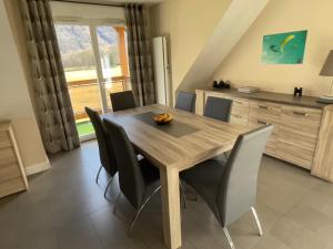 une salle à manger avec une table et des chaises en bois dans l'établissement Appartement duplex de standing au cœur des Pyrénées, à Luchon