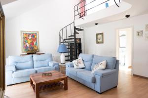 a living room with two blue couches and a table at Orquideas in Cala Galdana