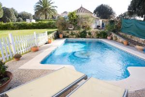 a swimming pool in a yard with a white fence at Orquideas in Cala Galdana