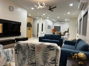 a living room with blue couches and a flat screen tv at Villanta by Villament in Karjat