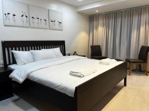 a bedroom with a large bed with two towels on it at Villanta by Villament in Karjat