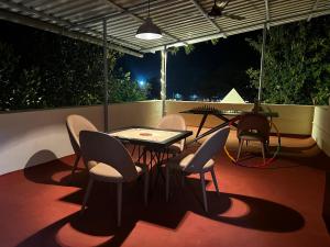 a table and chairs on a patio at night at Villanta by Villament in Karjat