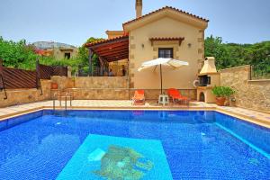 a swimming pool with a villa and a house at Villa Romantic Sevi by PosarelliVillas in Káto Vení