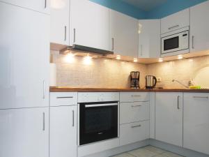 eine weiße Küche mit weißen Schränken und Geräten in der Unterkunft Ferienwohnung Hanna in Kühlungsborn