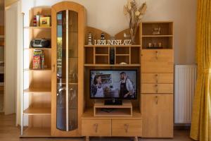 a tv in a wooden entertainment center in a living room at Ferienwohnung Elke in Kühlungsborn