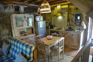 a kitchen with a table and a refrigerator at Casa do Ti João in Sabugueiro