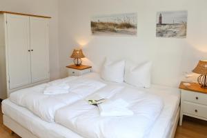 1 cama blanca con 2 toallas en un dormitorio en Sonnenresidenz II WE 10, en Kühlungsborn