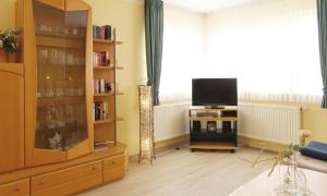 a living room with a tv and a book shelf at Ferienwohnung Christine in Kühlungsborn