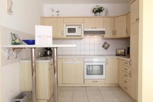 eine Küche mit Holzschränken und weißen Geräten in der Unterkunft Ferienwohnung Christine in Kühlungsborn