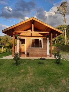 a small house with a large roof at Encanto das Rosas in Santo Antônio do Pinhal