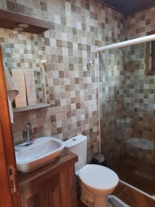 a bathroom with a toilet and a sink and a shower at Encanto das Rosas in Santo Antônio do Pinhal