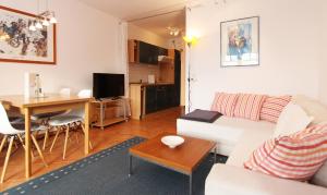ein Wohnzimmer mit einem weißen Sofa und einem Tisch in der Unterkunft Ferienwohnung Sonnenschein - direkte Meerlage in Kühlungsborn