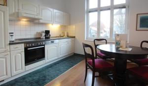 a kitchen with a table and a kitchen with white cabinets at Ferienwohnung Soldo in Kühlungsborn