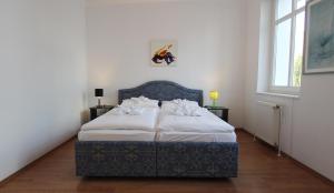 Schlafzimmer mit einem Bett mit weißer Bettwäsche und Kissen in der Unterkunft Ferienwohnung Soldo in Kühlungsborn