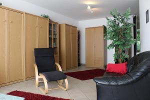 キュールングスボルンにあるFerienwohnung Grosse Krabbeのリビングルーム(黒い革張りのソファ、椅子付)