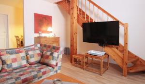 ein Wohnzimmer mit einem Sofa und einem Flachbild-TV in der Unterkunft Ferienwohnung Parkblick Nr. 22 in Kühlungsborn