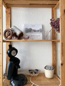 uma prateleira de madeira com um liquidificador e um livro em Studio et piscine sur la grande plage em Biarritz