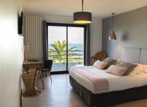 a bedroom with a bed and a view of the ocean at Villa Les Hydrangéas in Perros-Guirec