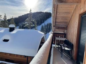 a snow covered balcony with a view of a mountain at Apartma Lilija Golte in Mozirje