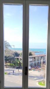 uma janela com vista para a praia e para o oceano em THE SUNSHINE LOFT em Livorno