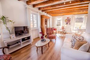 een woonkamer met een witte bank en een tv bij Lighthouse apartment in Corfu-stad