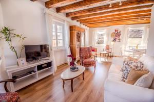 a living room with a white couch and a tv at Lighthouse apartment in Corfu Town