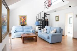 a living room with two blue chairs and a table at Orquideas in Cala Galdana