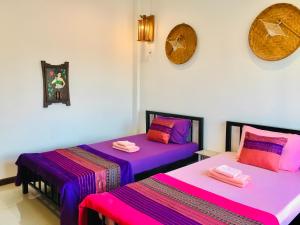 2 Betten nebeneinander in einem Zimmer in der Unterkunft Mae-Sa-Riang Home in Mae Sariang