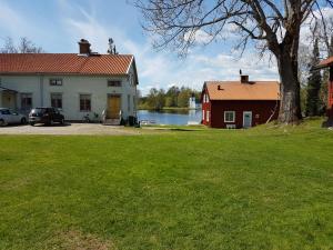 ein Haus und eine rote Scheune und ein See in der Unterkunft Lugnet i Oslättfors in Gävle