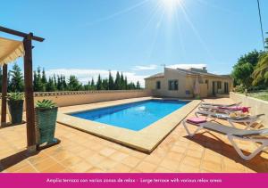 uma piscina com duas espreguiçadeiras e uma casa em Villa Berdica near Moraira em Benissa