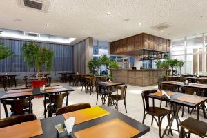 ein Restaurant mit Tischen und Stühlen in einem Raum in der Unterkunft Nacional Inn Rondonópolis in Rondonópolis