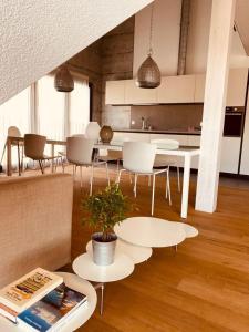 a kitchen with white tables and chairs and a table with a plant at Hotel de l’Ours Preles in Prêles