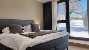 una camera con un grande letto e una grande finestra di Hotel de l’Ours Preles a Prêles