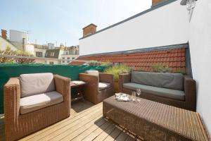 taras z dwoma krzesłami i stołem na balkonie w obiekcie Vienna Penthouse 1 w Wiedniu