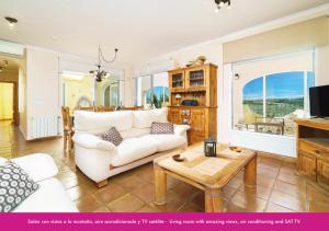 uma sala de estar com um sofá branco e uma mesa em Villa Berdica near Moraira em Benissa