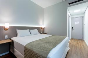 1 dormitorio con 1 cama grande en una habitación en Slaviero Rondonópolis, en Rondonópolis