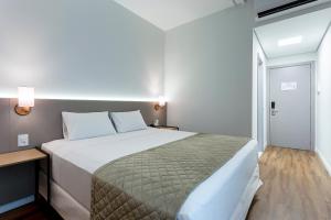 a bedroom with a large bed in a room at Slaviero Rondonópolis in Rondonópolis